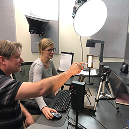Instructors collaborating in a video studio to create course content using professional lighting and camera equipment
