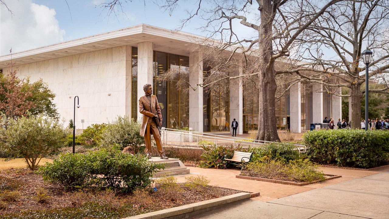 The bronze Richard T. Greener statue sits in front of the Thomas Cooper Library.