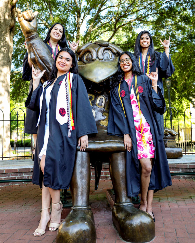 Two students walking down the brick path on a beautiful fall day.
