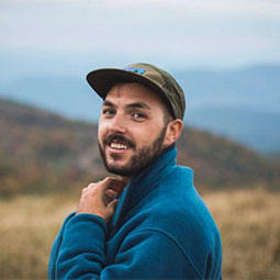 Zachary Brinchi Zachary Brinchi headshot with mountains in the background