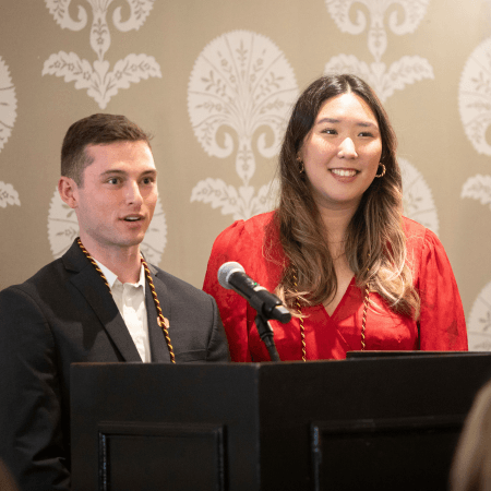 students speaking at podium