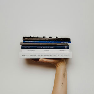 a hand holds up several books on their side